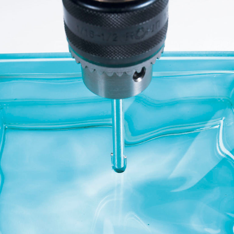 Uso de broca para vidrio RATIO realizando una perforación precisa en material cerámico con lubricación.