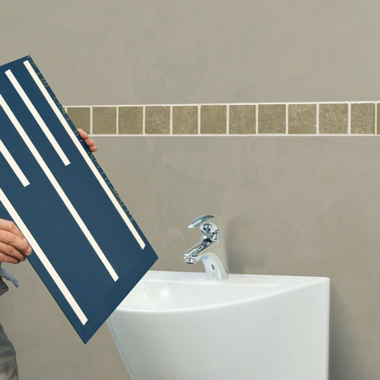 Aplicación de tiras de cinta doble cara tesa PRO en la parte trasera de un espejo para baño.