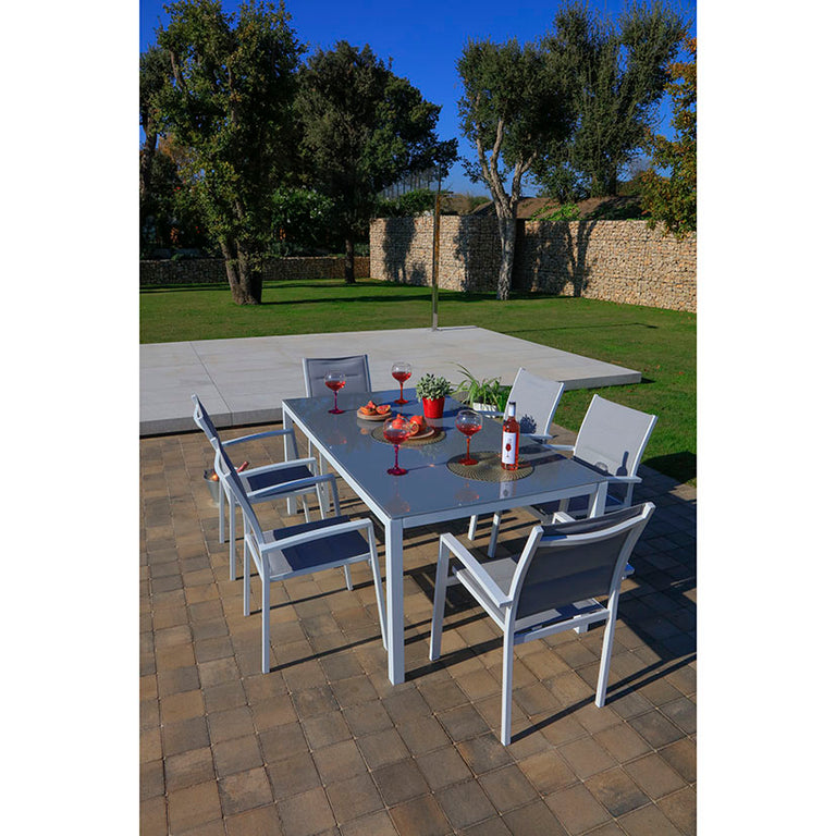 Mesa de exterior blanca con superficie de cristal y sillas de textilene
