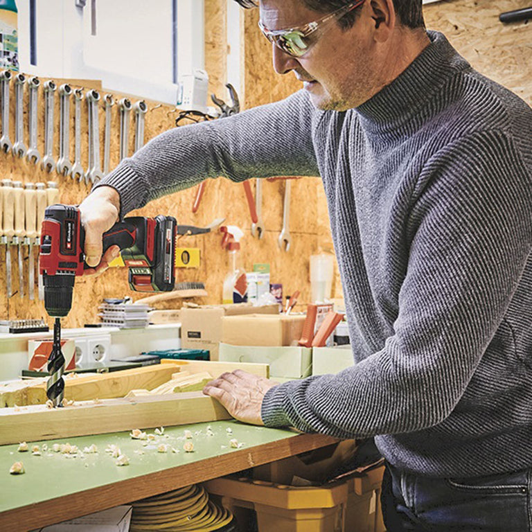 Usuario utilizando el taladro Einhell para perforar madera en un taller de bricolaje