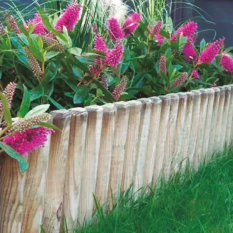 Detalle de bordura de madera instalada delimitando un parterre con flores rosas y césped en jardín exterior