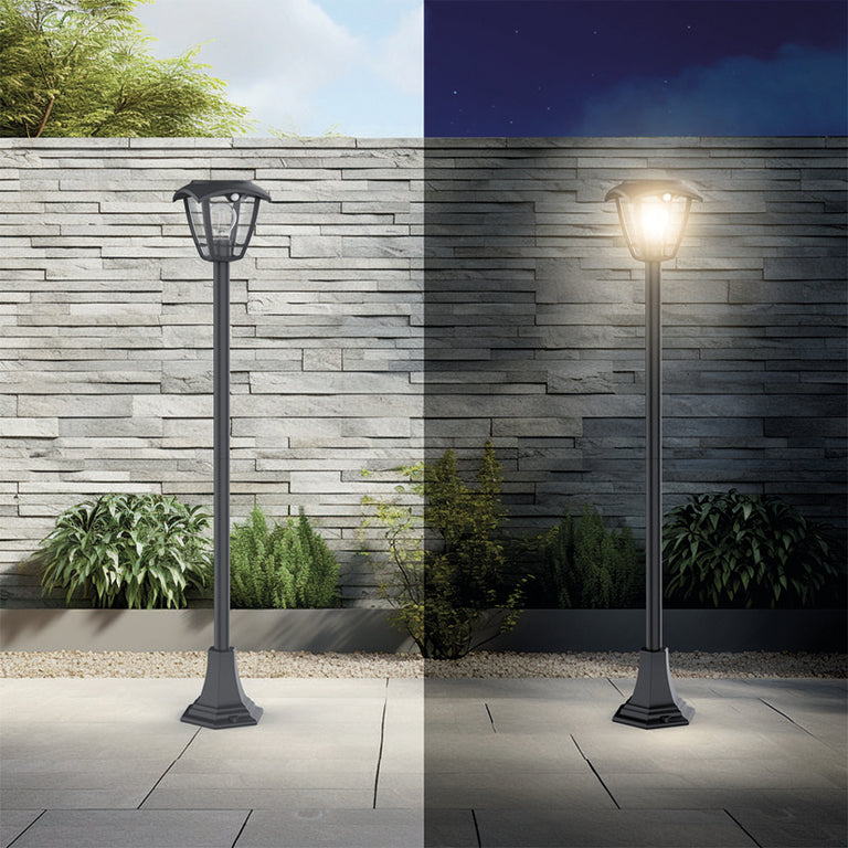 Comparativa día y noche de baliza solar negra de 110 cm instalada en un jardín moderno.