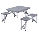 Mesa de picnic plegable color gris con cuatro asientos integrados y estructura de aluminio para exterior.