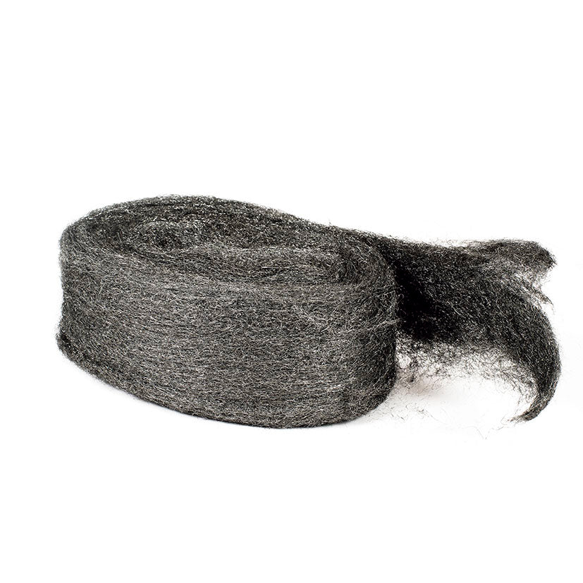 Madeja de lana de acero gris para pulido y limpieza de superficies de madera y metal.