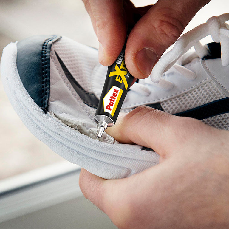 Reparación de la suela de una zapatilla deportiva blanca con el pegamento resistente Pattex Repair Extreme.