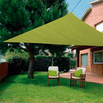 Toldo vela triangular verde pistacho proporcionando sombra en un jardín con césped y mobiliario de descanso.