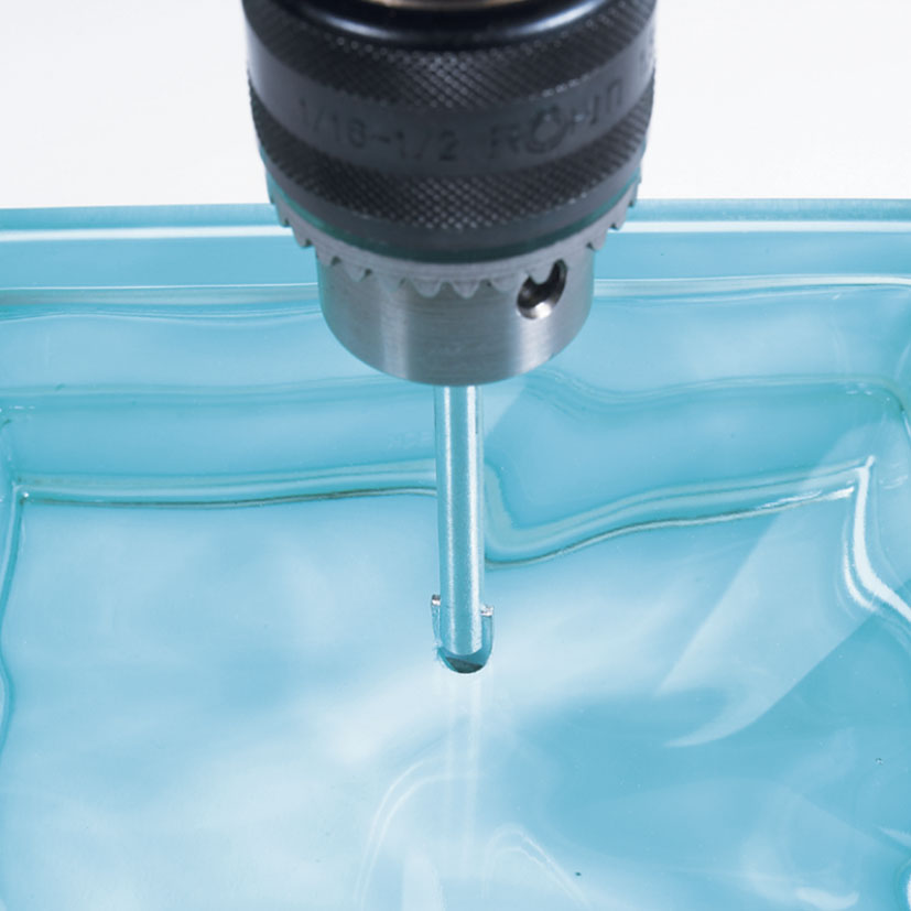 Uso de broca para vidrio RATIO realizando una perforación precisa en material cerámico con lubricación.