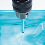 Uso de broca para vidrio RATIO realizando una perforación precisa en material cerámico con lubricación.