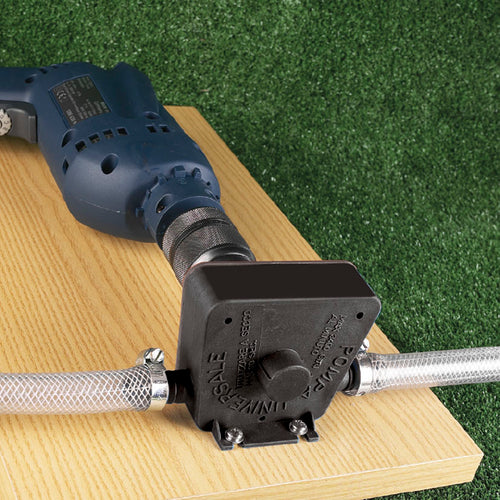 Bomba de trasvase RATIO conectada a un taladro eléctrico y mangueras sobre superficie de madera