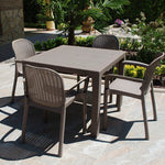Comedor de exterior con mesa taupé y sillas de resina imitación ratán