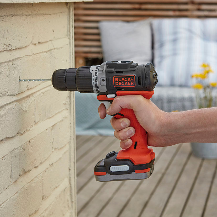 Uso de taladro percutor Black+Decker en pared de ladrillo mostrando su capacidad de perforación en mampostería.