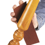 Lijado manual de pata de mueble de madera torneada con papel abrasivo RATIO de alta flexibilidad.