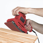 Lijadora eléctrica roja utilizando papel abrasivo RATIO sobre listones de madera natural.