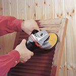 Amoladora angular con disco abrasivo autoadherente trabajando sobre persiana de madera.