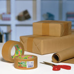 Cajas de cartón selladas con cinta de papel TESA ecoLogo mostrando un acabado profesional y ecológico.
