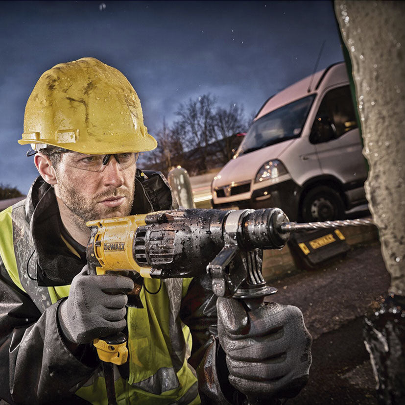 Operario profesional utilizando el martillo DEWALT para perforar una pared de hormigón en exteriores