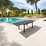 Mesa de jardín extensible Piazza color grafito en terraza con piscina.