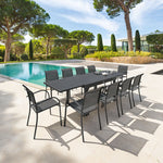 Mesa de jardín extensible Piazza color grafito con sillas a juego en terraza con piscina.