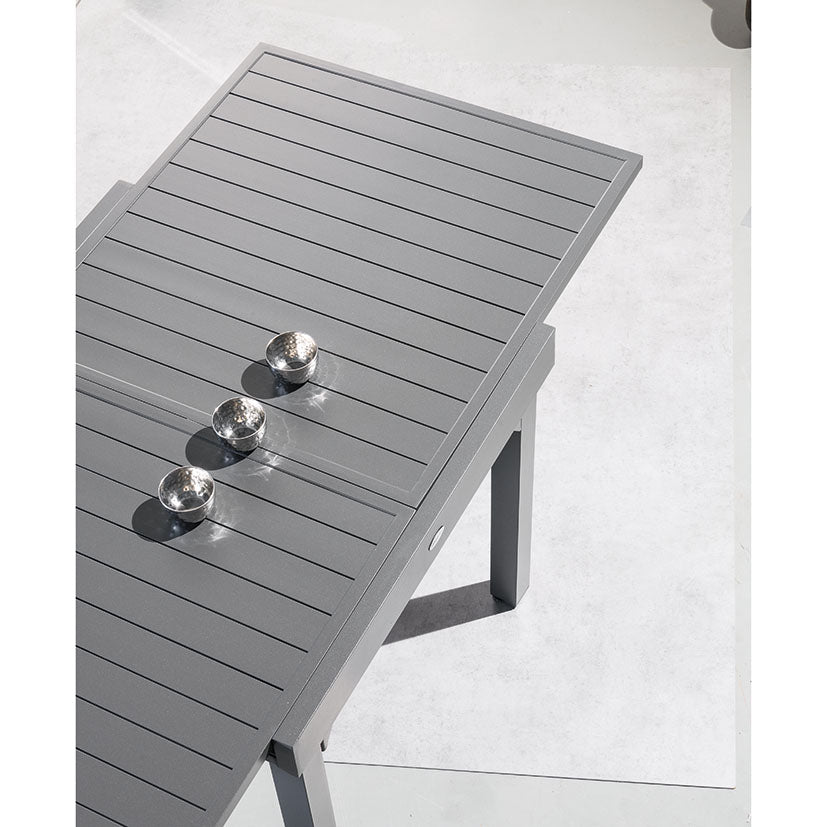 Primer plano del tablero de aluminio de la mesa Piazza grafito mostrando el sistema de extensión deslizante.
