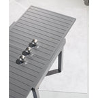 Primer plano del tablero de aluminio de la mesa Piazza grafito mostrando el sistema de extensión deslizante.