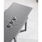 Primer plano del tablero de aluminio de la mesa Piazza grafito mostrando el sistema de extensión deslizante.