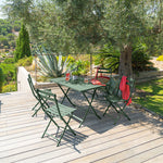 Comedor exterior en terraza de madera con mesa y sillas verdes plegables