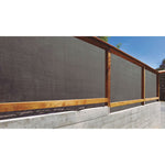 Valla de madera con malla de ocultación gris instalada para privacidad perimetral