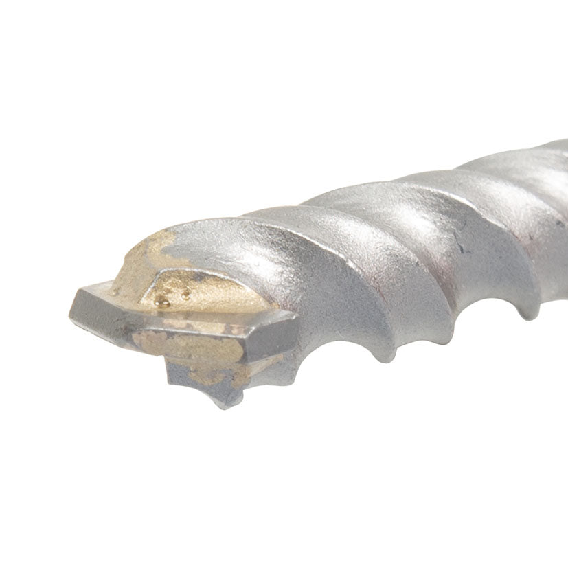 Primer plano de la punta de metal duro y espirales de evacuación de una broca para piedra profesional.