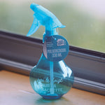 Botella pulverizadora azul de 330ml con etiqueta informativa sobre usos en el hogar y riego.