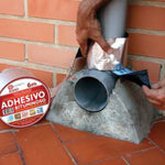 Aplicación manual de cinta bituminosa sobre tubería de PVC y base de hormigón para sellado estanco.