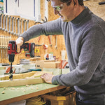 Usuario utilizando el taladro Einhell para perforar madera en un taller de bricolaje