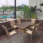 Mesa de comedor exterior Vancouver en ratán sintético beige con sillones a juego en terraza de madera.