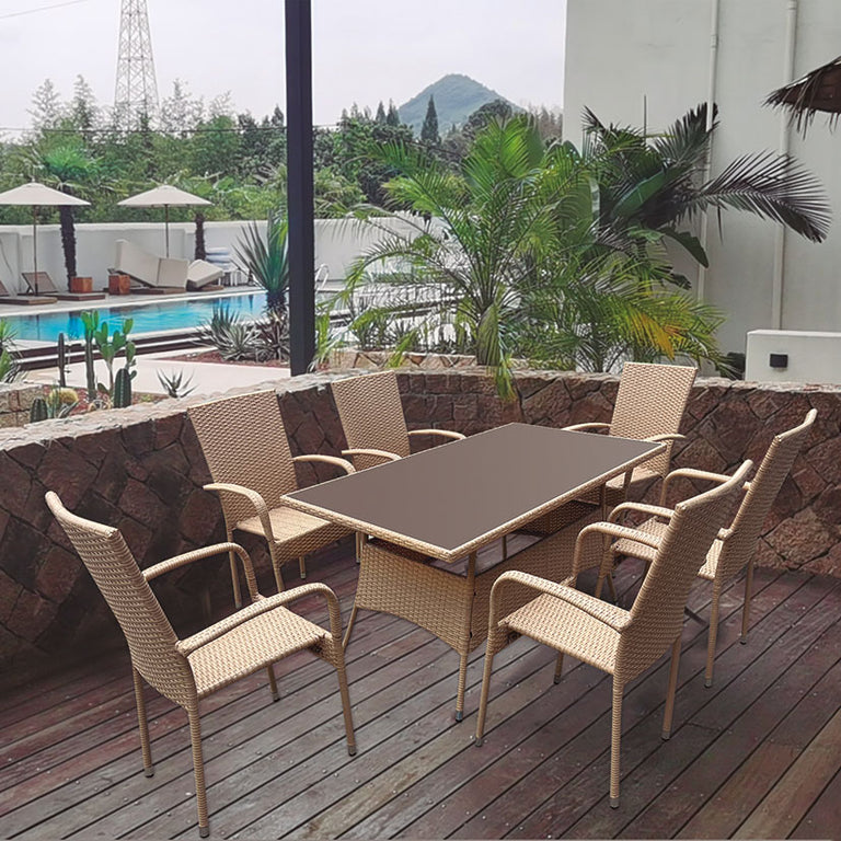 Mesa de comedor exterior Vancouver en ratán sintético beige con sillones a juego en terraza de madera.