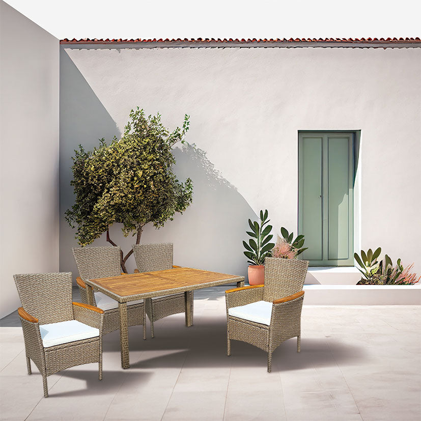 Comedor exterior Tahití con mesa de madera y sillones de ratán en una terraza de estilo mediterráneo.