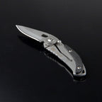 Navaja TRUE SkeletonKnife sobre superficie oscura resaltando su clip de bolsillo y acabados metálicos.