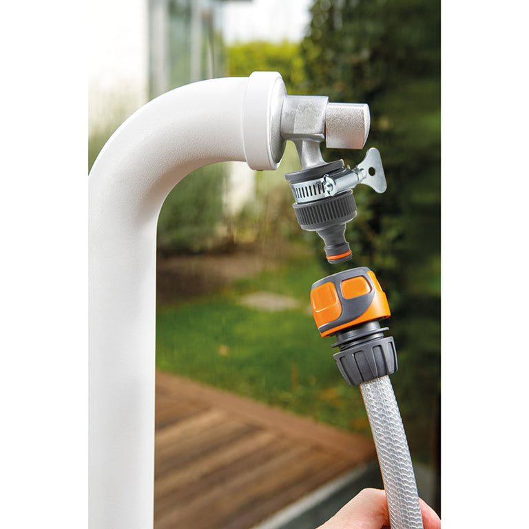 Adaptador LISTA instalado en grifo de jardín sin rosca conectando una manguera de riego mediante conector rápido.