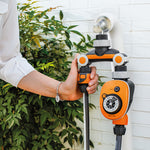 Distribuidor de riego LISTA instalado en grifo exterior con programador de riego y manguera conectados.