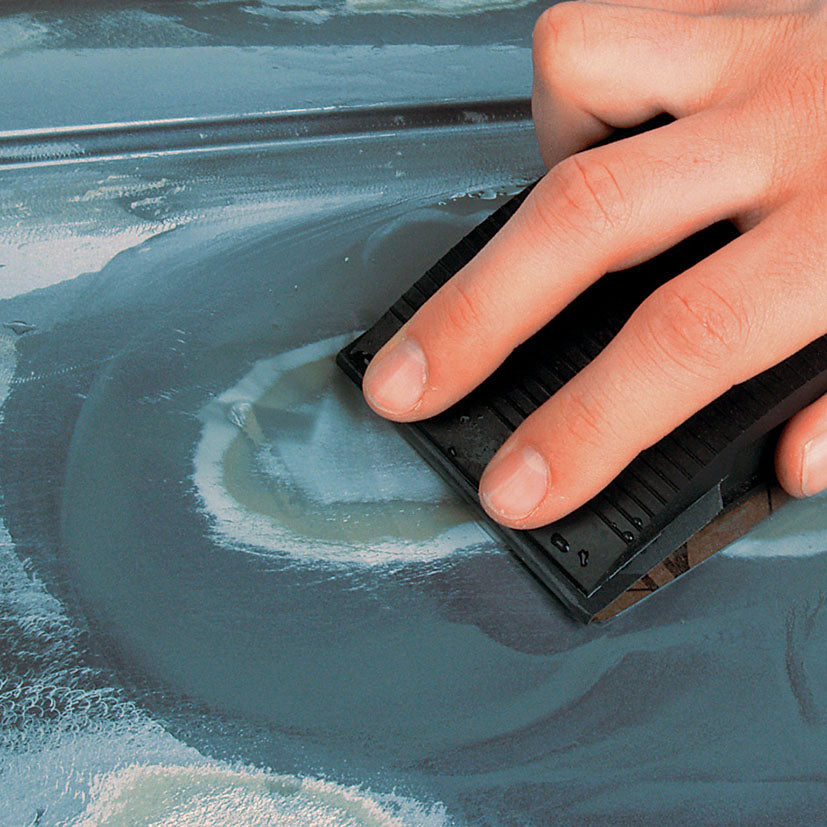 Lijado al agua con taco manual sobre superficie metálica pintada