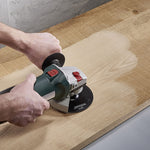 Amoladora angular con plato Wolfcraft lijando superficie de madera natural
