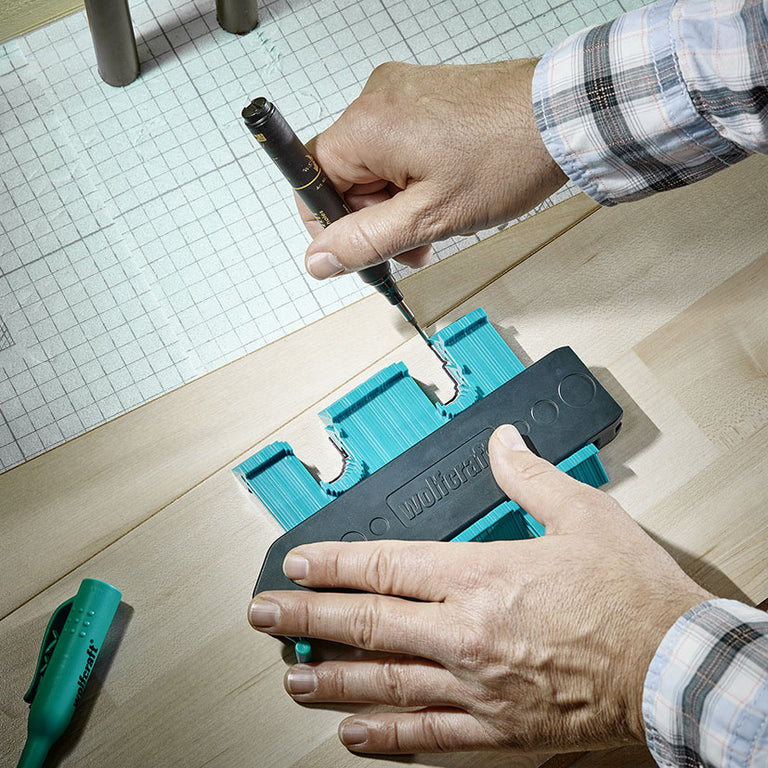 Transferencia del perfil copiado con el calibre Wolfcraft a una tabla de madera usando un marcador de precisión