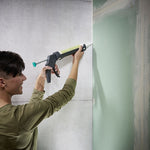 Usuario sellando esquina de pared de hormigón con pistola de cartuchos Wolfcraft MG 100.