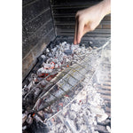 Pescado cocinándose directamente sobre las brasas con la parrilla de acero inoxidable Sauvic.