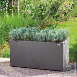 Jardinera rectangular Deroma Millennium con plantas verdes decorando un espacio exterior soleado