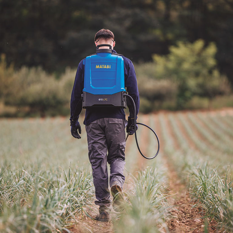 Hombre trabajando en campo agrícola con pulverizador de mochila eléctrico Matabi E15 LTC
