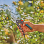 Persona utilizando la tijera de jardín GARDENA para podar arbustos con una sola mano de forma ergonómica.