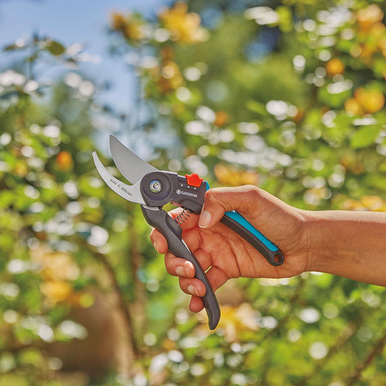 Persona utilizando la tijera de jardín GARDENA para podar arbustos con una sola mano de forma ergonómica.