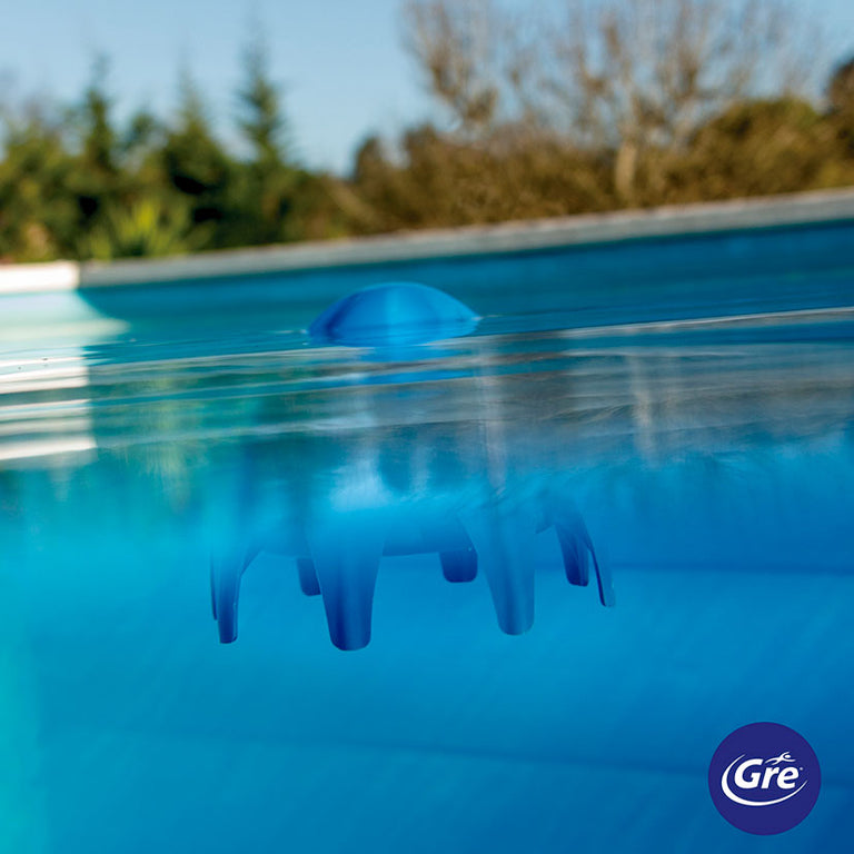 Tratamiento Poolp'O flotando en la superficie de una piscina de agua cristalina