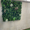 Jardín vertical artificial modelo Otoño de 100x100 cm instalado en una pared exterior de piedra clara.