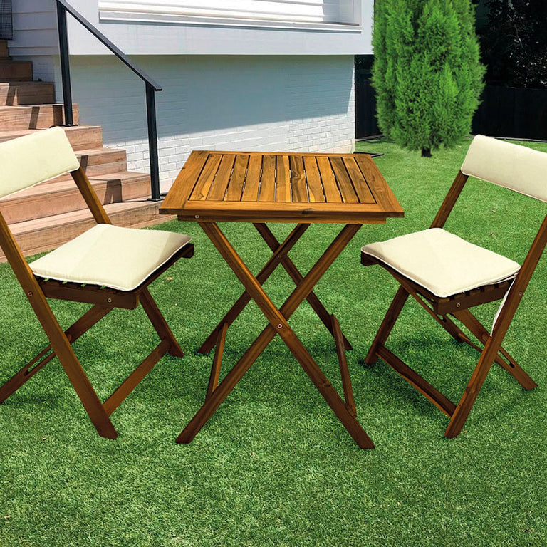 Set de muebles de madera para terraza con mesa y sillas plegables ubicados en un jardín exterior con césped.