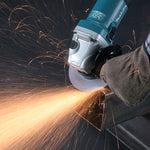 Amoladora Makita GA5040RZ realizando corte en metal con chispas y sistema SJS II de reducción de vibraciones.